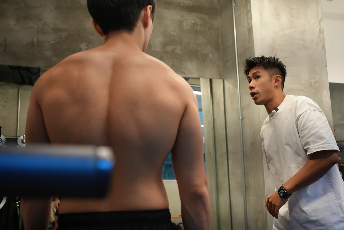 Taka 站在學員背後,觀察他背部與肩胛的狀態