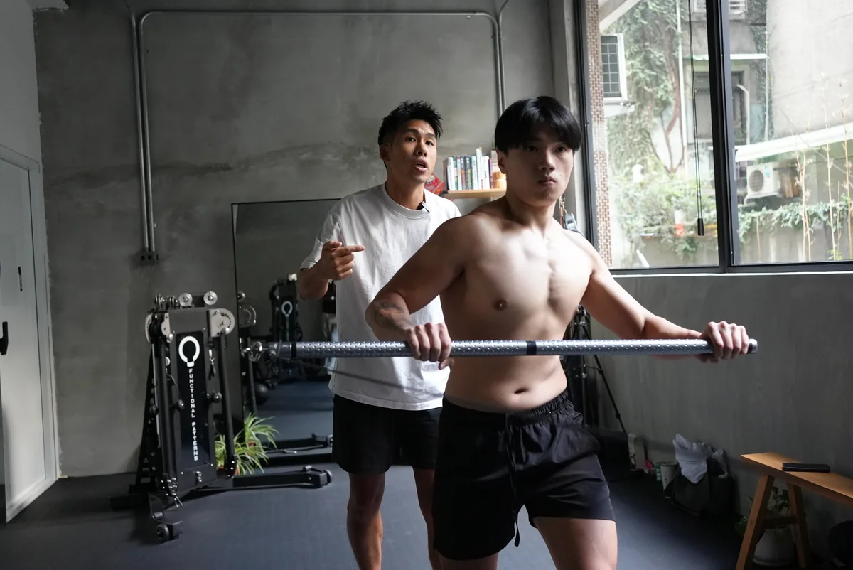 第一力學工作室一角,Taka 在學員身後指導橫桿動作